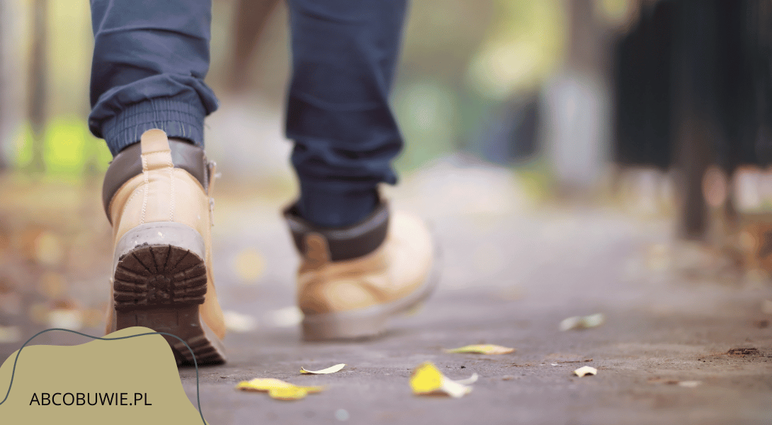 Zbliżenie na męskie stopy w wodoodpornych butach softshellowych podczas jesiennego spaceru